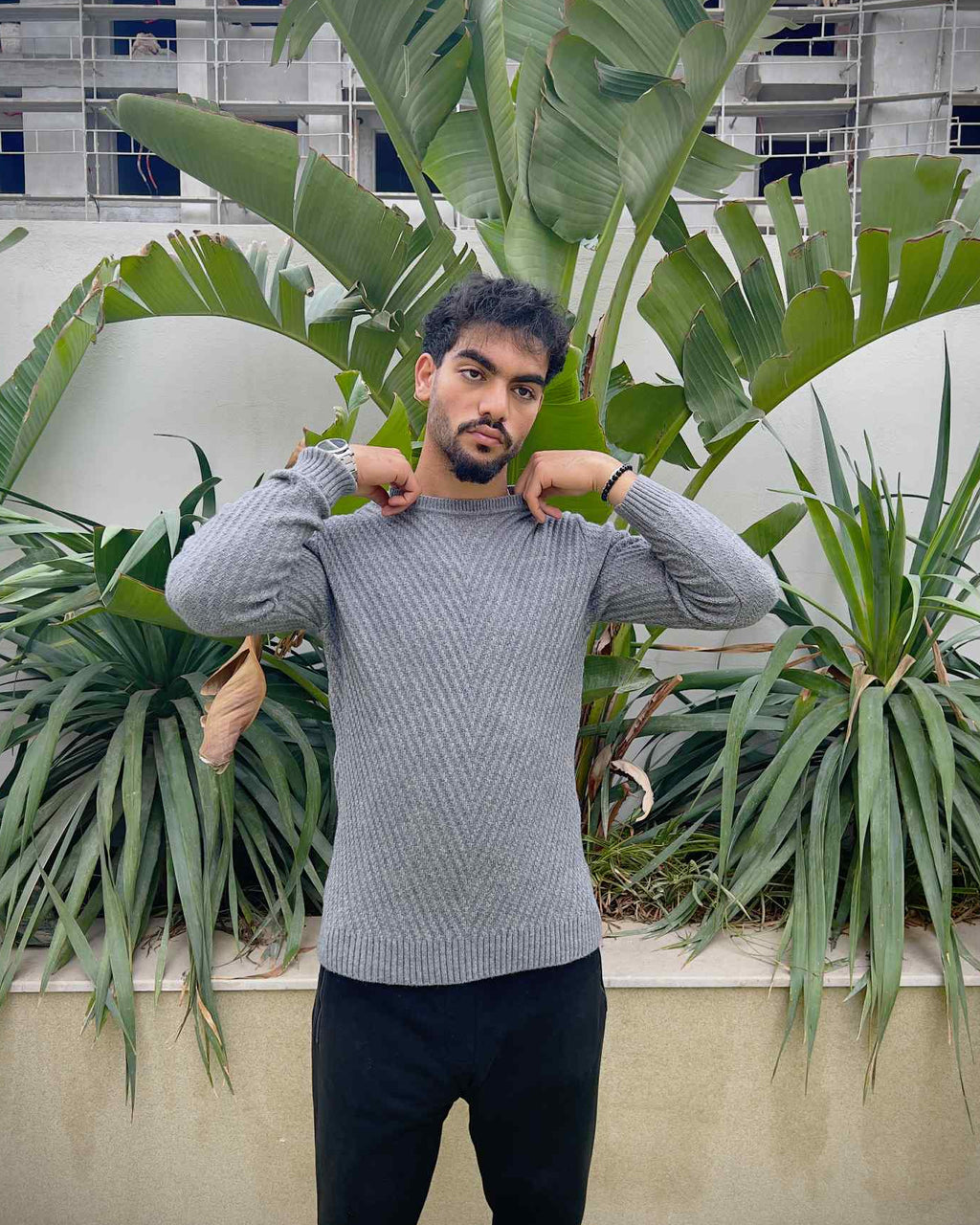 Man wearing a grey sweater and dark pants 