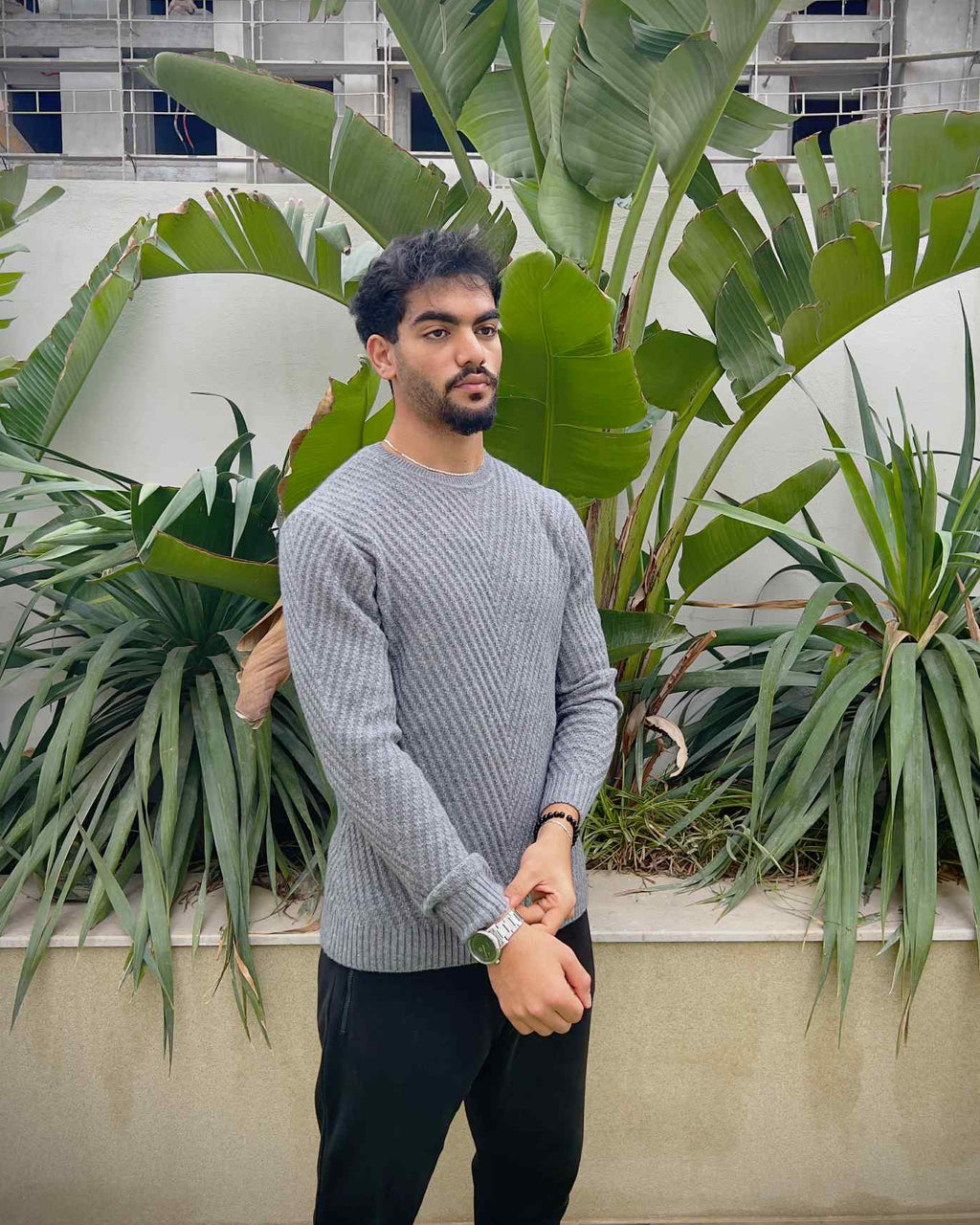 Man wearing a grey sweater and dark pants 